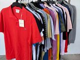 a lot of shirts hanging on a rack in a room