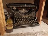 an old typewriter sitting on the floor in the kitchen
