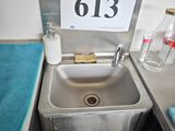 un lavabo dans un coin de la salle de bains, avec une pancarte au-dessus