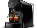 une machine à café noire avec deux tasses de café devant elle