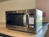 a silver microwave sitting on a counter in a kitchen