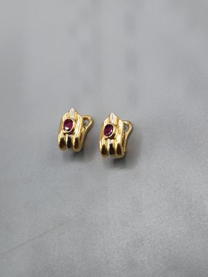 a pair of gold earrings with a ruby stone in the middle