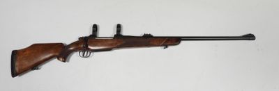 un fusil accroché au mur, avec une arme posée dessus