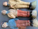 three wooden figurines of people are sitting on a table