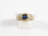 gros plan d'une bague avec une pierre bleue et des diamants