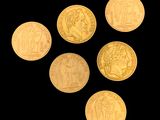 six gold coins are arranged in a triangle on a black background