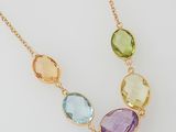 a close up of a necklace with three different colored stones