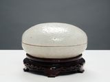 un bol blanc posé sur un socle en bois
