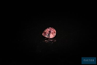 un diamant rose sur une surface noire