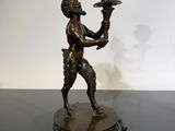 an image of a bronze statue of a man holding a cup