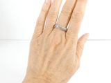 a woman ' s hand with a diamond ring on it