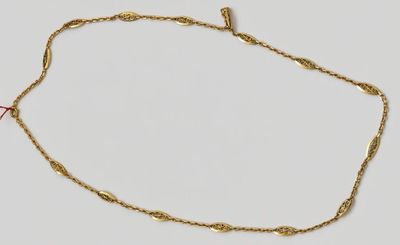 gros plan d'un collier en or sur une surface blanche
