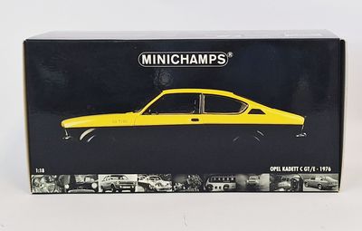 maquette jaune d'une voiture dans une boîte noire posée sur une surface blanche