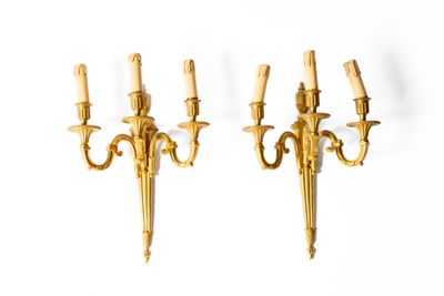 Paire d'appliques éclairant par trois lumières en bronze dor…