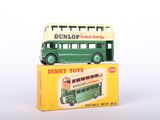 a green and white double decker bus on top of a box