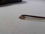 a small wooden stick sitting on a table next to a suitcase