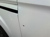 a white car with a hole in the side of it