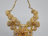 a gold necklace on a white background with a price tag