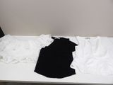 a white table topped with three pairs of black and white shirts