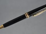 a close up of a pen with a black and gold trim