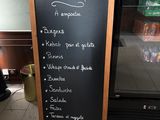 a chalk board with a menu written on it in front of a freezer