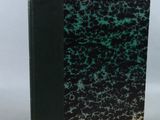 a black and green book sitting on top of a white table