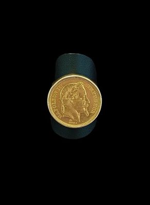 gros plan d'une pièce d'or sur une surface noire