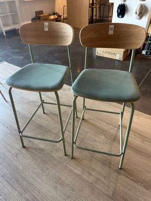 two green chairs sitting on top of a wooden floor next to each other