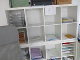 une bibliothèque blanche sur laquelle sont posés de nombreux livres