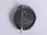 a silver coin with an eagle on it on a white surface