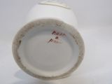 a close up of a white cup on a white surface