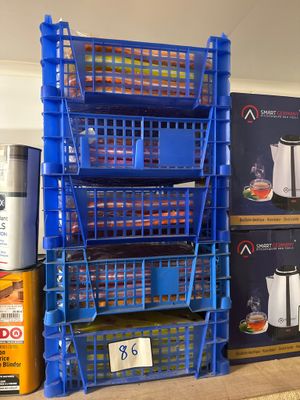 une pile de caisses bleues et une cafetière posées par terre
