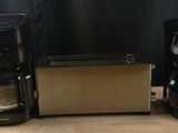 two coffee makers and a toaster sitting on a table