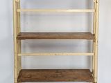 an image of a wooden shelf with four shelves and a suitcase on top