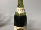 une bouteille de vin posée sur une table, à côté d'un verre de vin