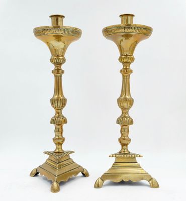 paire de chandeliers anciens en laiton sur piédestal sur fond blanc