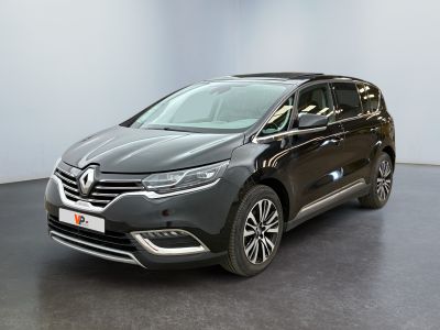 Une voiture grise est garée dans une pièce au sol noir.