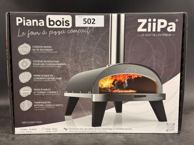 La boîte du four à pizza est ouverte et prête à être mise au four.