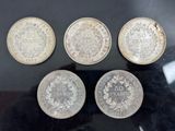 four different types of coins on display in a glass case