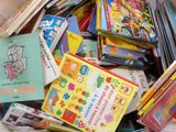 une pile de livres pour enfants dans un panier posé par terre