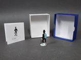 a small figurine of a man standing in a box
