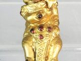a gold figurine of a monkey holding a teddy bear