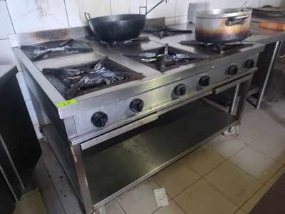 une cuisinière sur laquelle est posée une marmite dans une cuisine