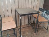 three chairs and a table on a wooden deck