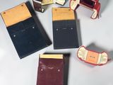 Quatre portefeuilles en cuir de couleurs différentes sont disposés sur une surface blanche