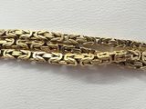 a close up of a napkin with a gold bracelet on it