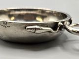 un bol en argent orné d'un poisson, posé sur une table