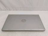 laptop computer sitting on a bed with a white sheet in the background