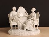 une figurine représentant deux personnes assises à une table