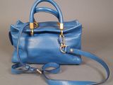 a picture of a blue handbag on a gray background